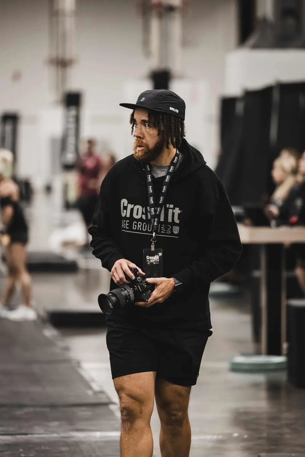 Tyler Thompson walking the floor of a CrossFit competition with a camera in hand