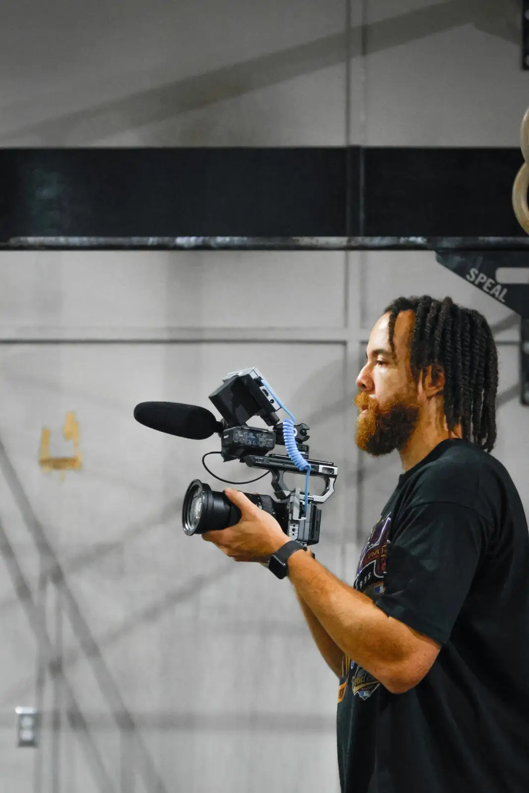 Tyler Thompson filming with a handheld camera rig and a shotgun microphone